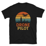 Black unisex t‑shirt with retro sunset circle, city skyline silhouette, quadcopter drone, and bold DRONE PILOT text in orange and yellow