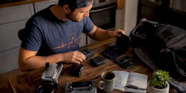 Man sorting drone gift accessories at home desk