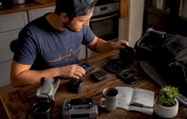 Man sorting drone gift accessories at home desk